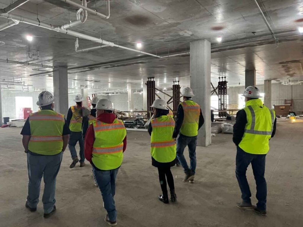group of people in construction vests in a warehouse job site