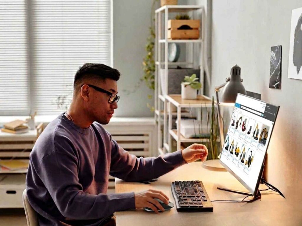 man working from home on his computer sourcing construction equpment
