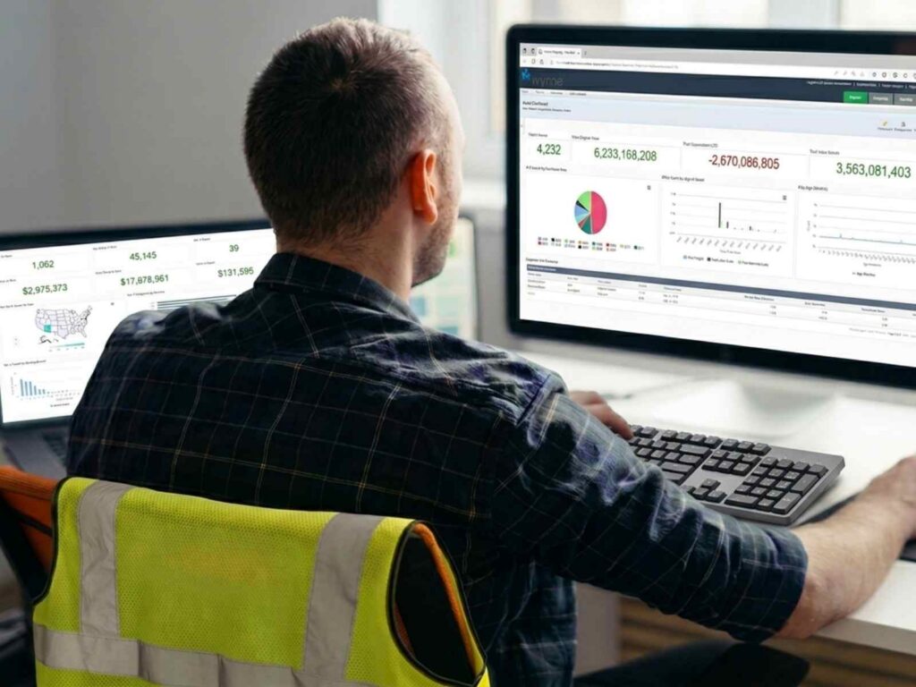man using reporter software with a construction vest on his chair