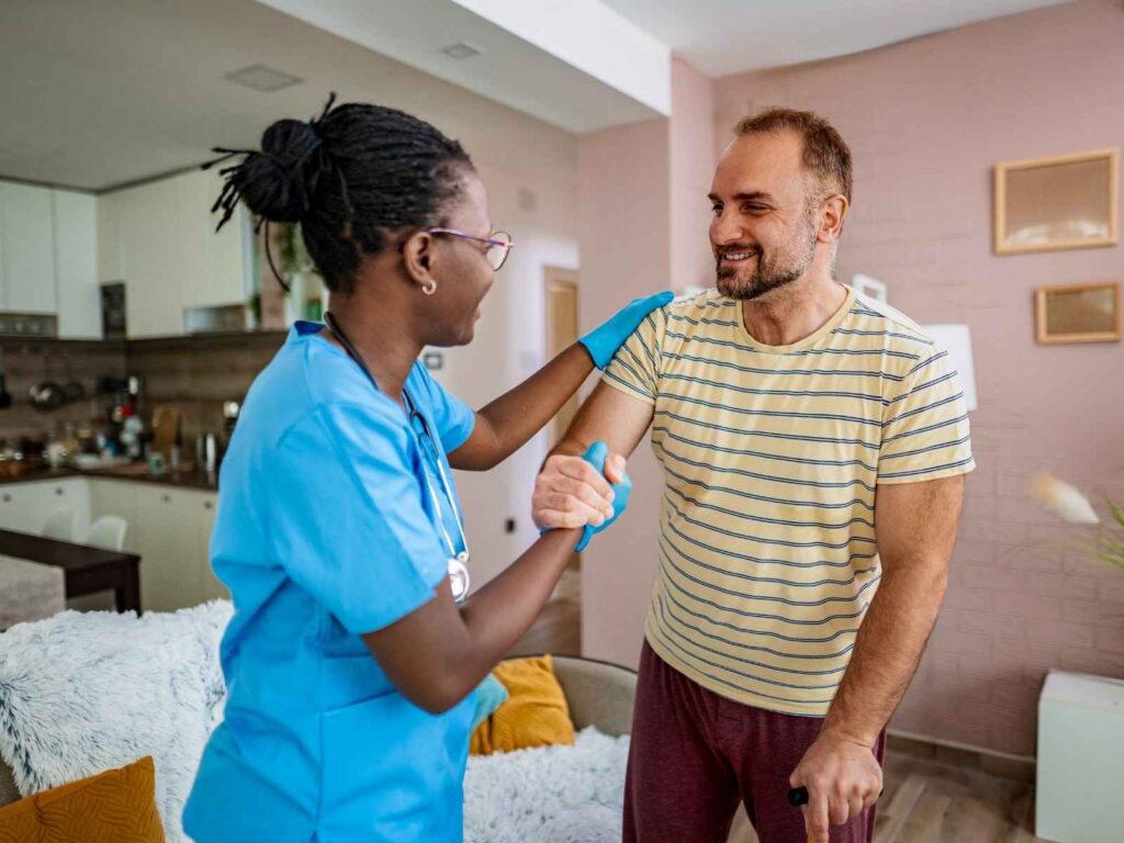 Friendly Caregiver Visiting Man at Home for Checkup
